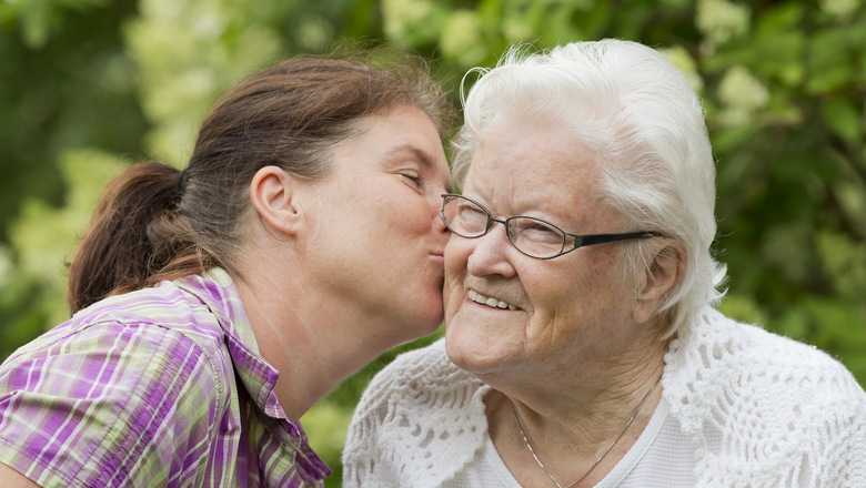 Bild på en kvinna som pussar en äldre kvinna på kinden.