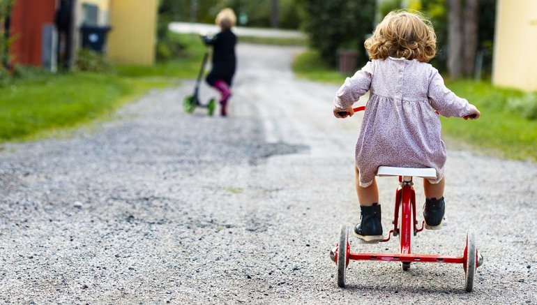 Barn på trehjuling och sparkcykel