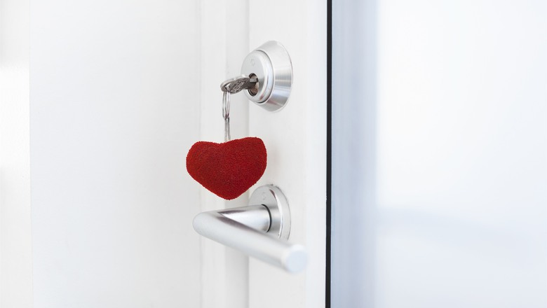 en nyckel med hjärtnyckelring hänger i ett lås