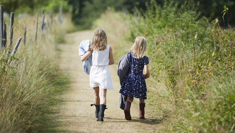 Två flickor som går på en liten stig.