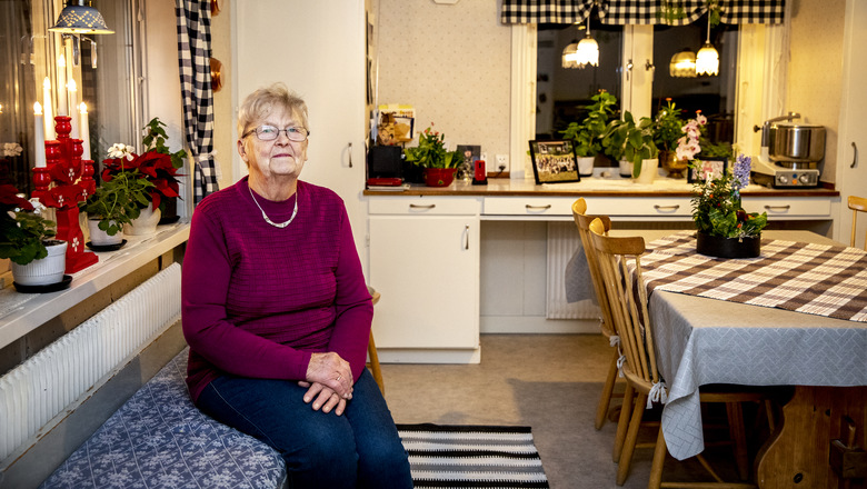 Äldre kvinna sitter på sin kökssoffa