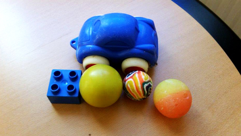 Blå leksaksbil, bollar, studsbollar och en legobit. Hittat på reningsverk.