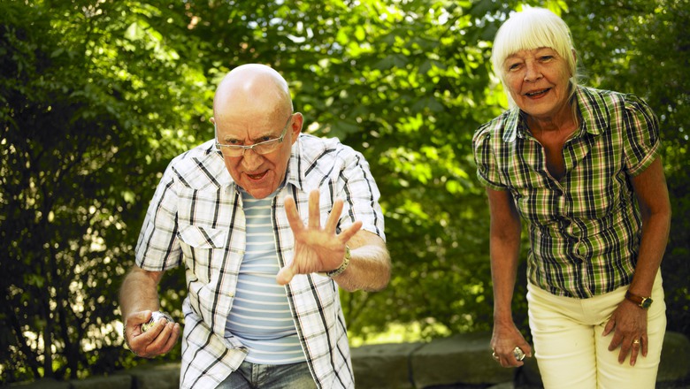 två glada seniorer spelar boule